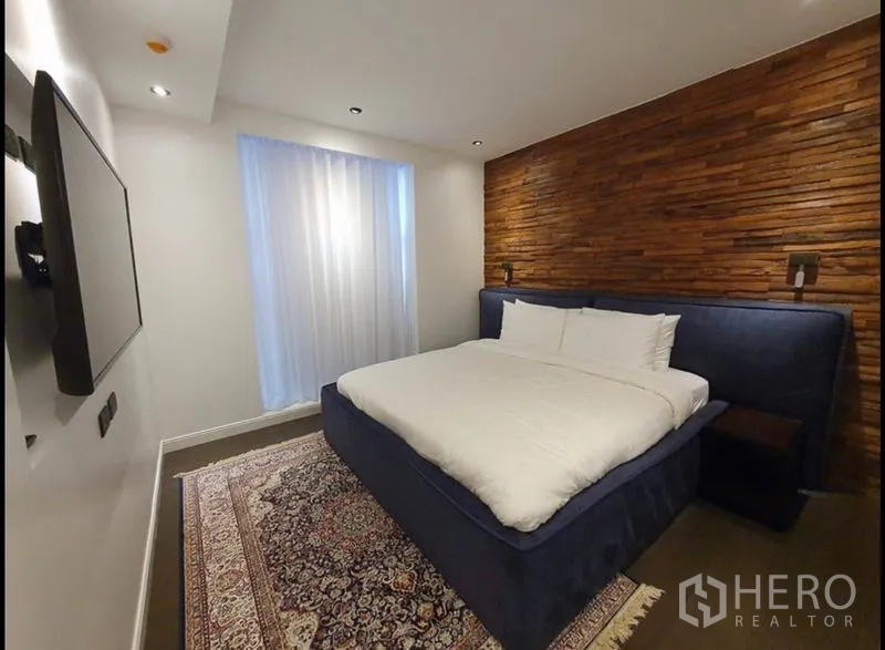 คอนโด ให้เช่าในWatthana, Bangkok - ห้องนอนบรรยากาศอบอุ่น ผนังไม้โชว์ลาย เตียงใหญ่ และแสงไฟนุ่มนวล