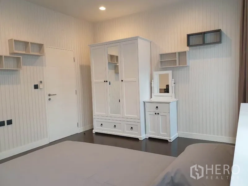 บ้าน ให้เช่าในBang Kapi, Bangkok - ผนังห้องนอนพร้อมตู้เสื้อผ้าสีขาว โต๊ะเครื่องแป้ง และชั้นลอย.