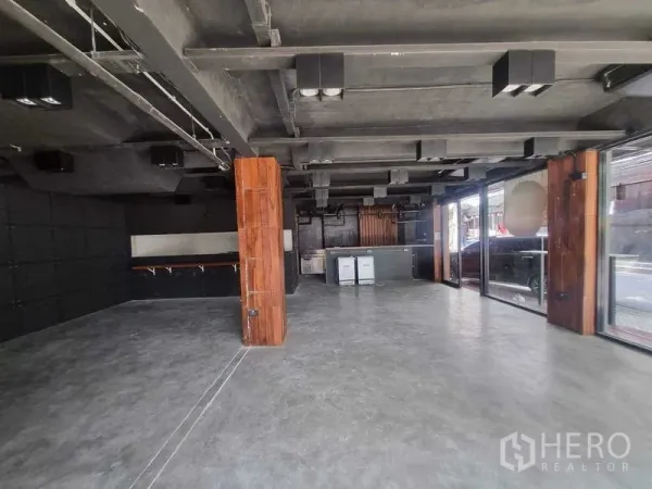 零售空间 出租在Bang Rak, Bangkok - 宽敞零售大厅，混凝土地面、木立柱与落地窗。