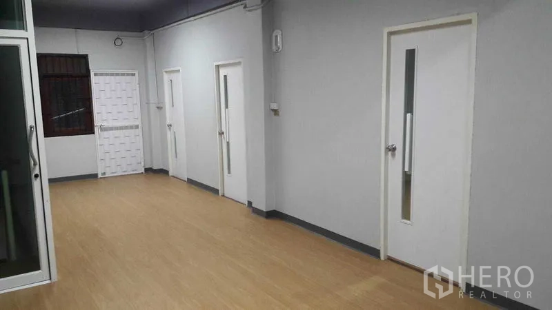 店屋 出租在Khlong Toei, Bangkok - 长走廊，设多扇白门与推拉玻璃隔断。