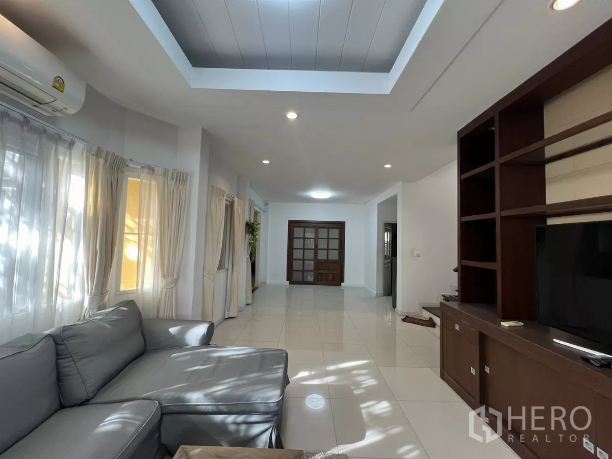 Detached House for rent in Bang Kapi, Bangkok - Spacious living zone with recessed ceiling lights and a wall-to-wall TV cabinet.