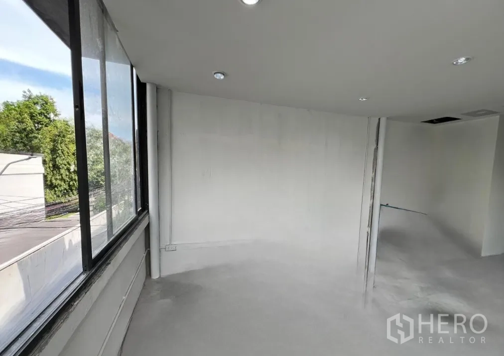 零售空间 出租在Khlong Toei, Bangkok - 白墙开间零售空间，转角窗与嵌灯