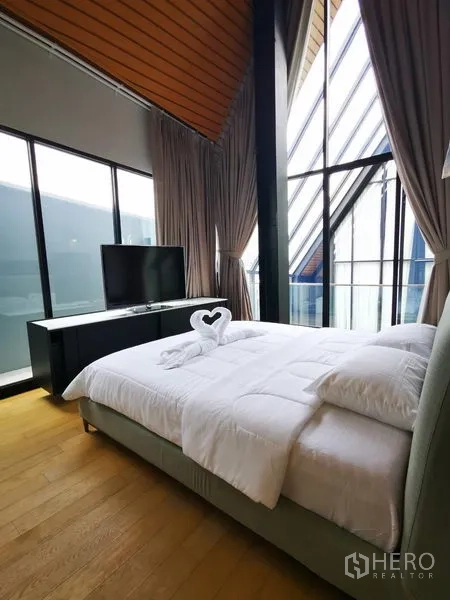 อพาร์ทเมนท์ ให้เช่าในKhlong Toei, Bangkok - ห้องนอนสว่างด้วยกระจกสูงจรดเพดาน มีชั้นวางทีวีและชุดเครื่องนอนนุ่มสบาย