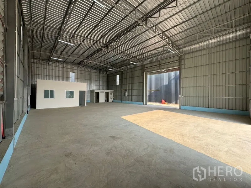 货栈 出租在Lam Luk Ka, Pathum Thani - 宽敞仓库内部，高钢梁屋顶、装卸大门与独立小办公室。