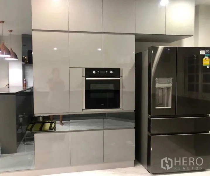 Home Office for rent or sale in Pak Kret, Nonthaburi - Glossy built-in kitchen cabinets with wall oven and a large double-door refrigerator.