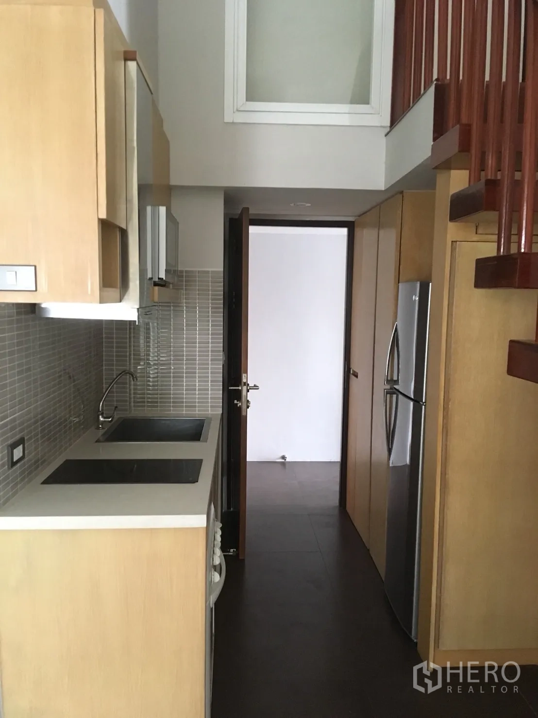 คอนโด ให้เช่าหรือขายในWatthana, Bangkok - ครัวแบบแกลเลอรี ตู้ไม้โทนอ่อน อ่างล้างจานคู่ ผนังโมเสก และบันไดขึ้นชั้นลอย