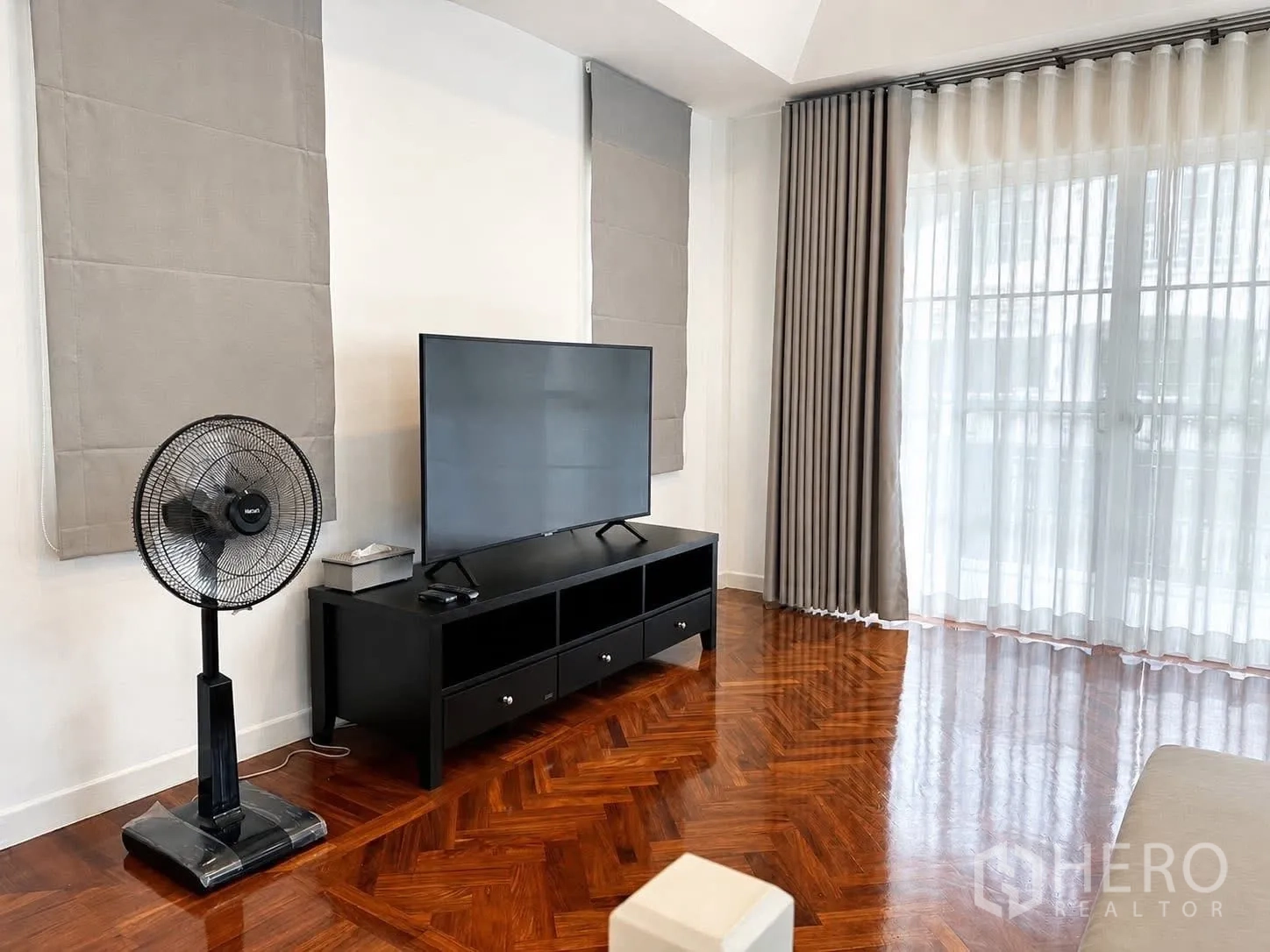 บ้านเดี่ยว for rent in Prawet, Bangkok - มุมทีวีพร้อมตู้วางทีวี พัดลมตั้งพื้น และพื้นไม้ลายก้างปลา