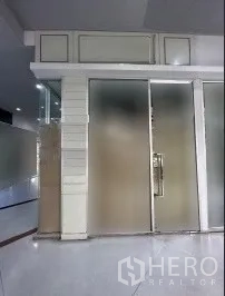 Retail Space for rent in Khlong Toei, Bangkok - Compact indoor retail unit with frosted glass sliding doors, aluminum frames, and bright tiled flooring in a mall corridor.