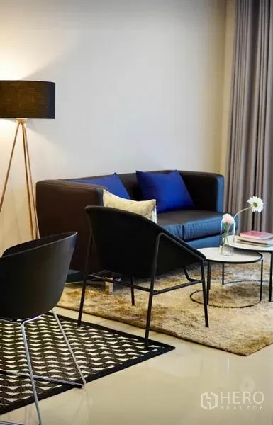 ทาวน์เฮาส์ ให้เช่าหรือขายในWang Thonglang, Bangkok - ห้องนั่งเล่นสไตล์โมเดิร์น โซฟาสีเข้ม โคมไฟตั้งพื้น และโต๊ะกลางบนพรม