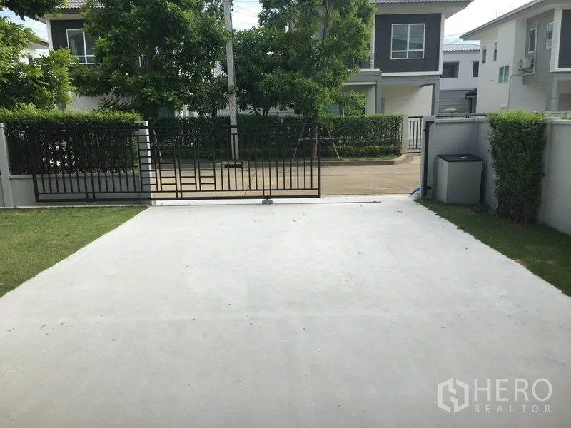 บ้าน ให้เช่าในKhlong Luang, Pathum Thani - มุมมองจากที่จอดรถสู่ประตูรั้วและถนนภายในหมู่บ้าน