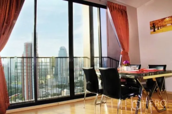 Condominium for rent or sale in Watthana, Bangkok - Bright dining area with curtains and panoramic Bangkok skyline through sliding doors.