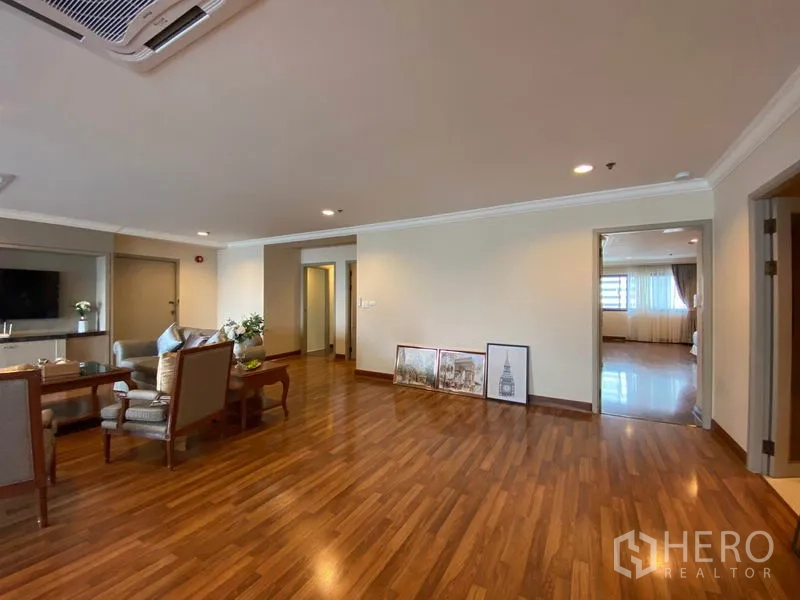Condominium for rent in Watthana, Bangkok - Living room with seating set, wood flooring and doorway leading to a bedroom.