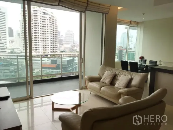Condominium for rent or sale in Bang Rak, Bangkok - Bright living room with leather sofas opening to a balcony with Bangkok city skyline views.