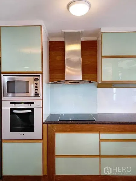 คอนโด ให้เช่าในWatthana, Bangkok - ภาพระยะใกล้ของครัว เตาอินดักชัน เครื่องดูดควันสแตนเลส ไมโครเวฟและเตาอบบิลท์อิน พร้อมตู้สีพาสเทล.