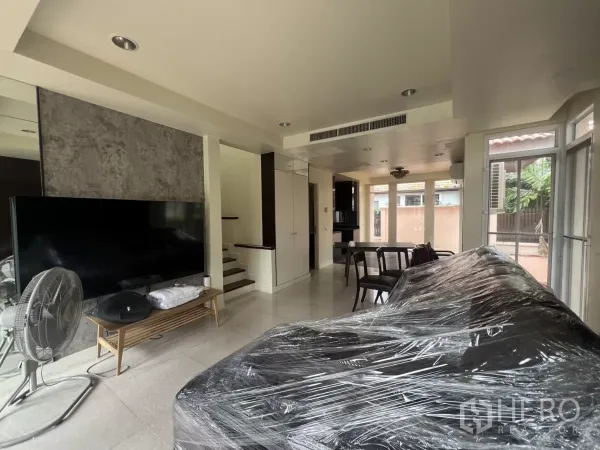 บ้าน ให้เช่าในWang Thonglang, Bangkok - มุมห้องนั่งเล่นเชื่อมส่วนทานอาหารและบันไดพร้อมกระจกสูงจรดพื้น