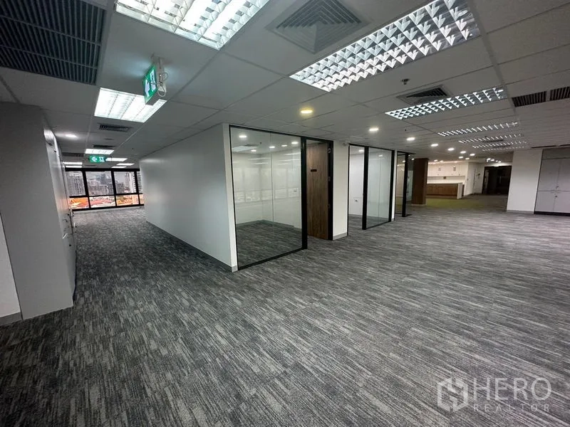 สำนักงาน ให้เช่าในKhlong Toei, Bangkok - โถงสำนักงานมีห้องประชุมกั้นกระจก ป้ายทางออกฉุกเฉิน ไฟฝ้า และพื้นพรมสีเทา