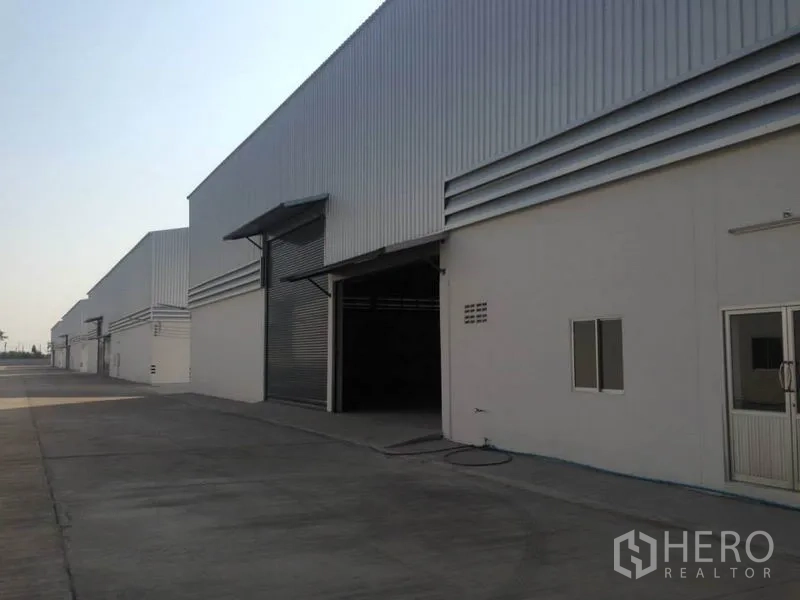Warehouse for rent in Bang Bua Thong, Nonthaburi - Row of steel‑clad warehouses with large loading doors and canopies in Nonthaburi.