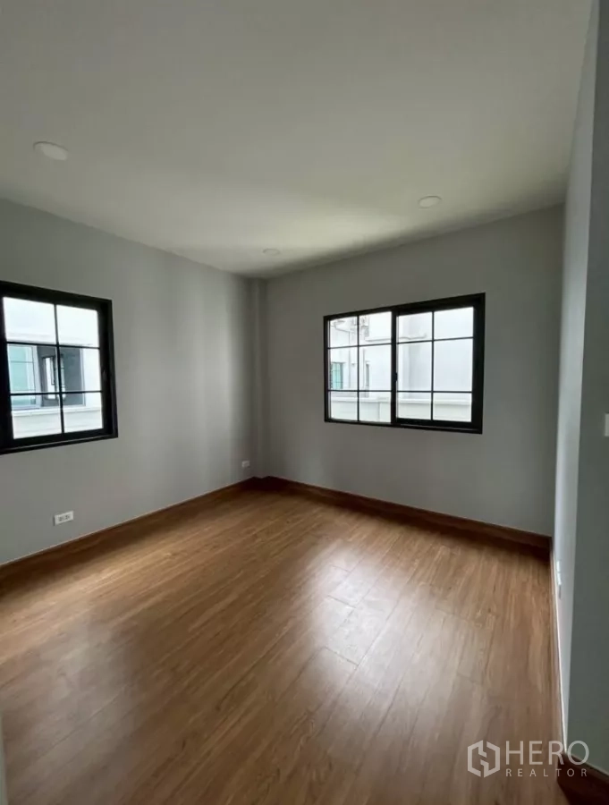 独立式住宅 出租在Bang Phli, Samut Prakan - 次卧，木地板与两扇窗户。