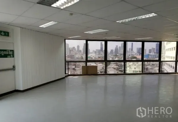 办公空间 出租在Pathum Wan, Bangkok - 采光充足的转角工位，吊顶、光洁地面与城市景观。