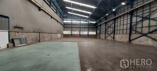 货栈 出租在Mueang Samut Prakan, Samut Prakan - 高架照明与十字支撑钢墙，绿色环氧作业区。