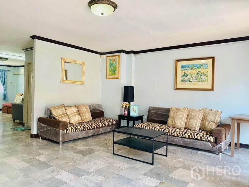 ทาวน์เฮาส์ ให้เช่าหรือขายในPrawet, Bangkok - ห้องนั่งเล่นกว้าง โซฟาคู่ โต๊ะกลาง งานศิลป์ติดผนัง และพื้นกระเบื้อง