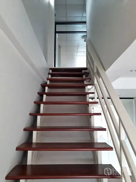 Townhouse for sale in Bang Kapi, Bangkok - Close-up of wooden staircase with white railing leading to the upper floor.