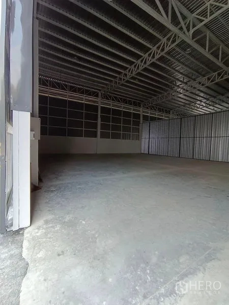 货栈 出租在Khlong Toei, Bangkok - 从大门向内的仓库视角，高桁架顶与水泥地面