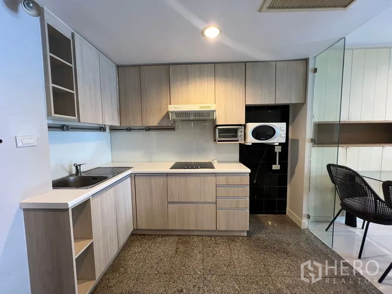 คอนโด ให้เช่าหรือขายในKhlong Toei, Bangkok - ครัวรูปตัวแอลตู้ลายไม้ พร้อมเตาและเครื่องดูดควัน