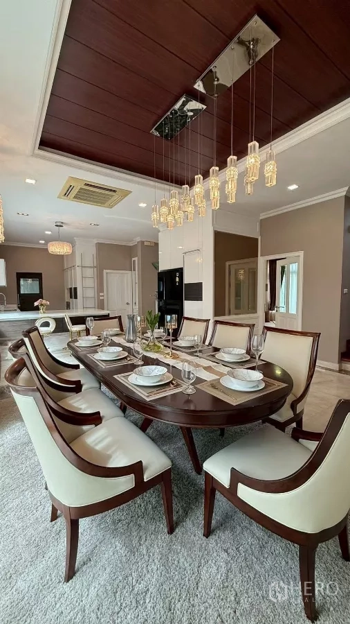 Detached House for rent or sale in Bang Phli, Samut Prakan - Formal dining room with eight‑seat table and pendant lights under wood ceiling