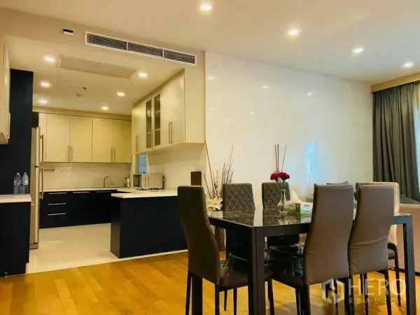Condominium for rent in Watthana, Bangkok - Open-plan dining area with a marble-top table and view of the fitted kitchen.