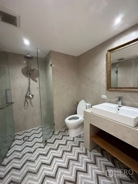 คอนโด ให้เช่าในKhlong Toei, Bangkok - ห้องน้ำสมัยใหม่พร้อมห้องอาบน้ำกระจก โถสุขภัณฑ์ และอ่างล้างหน้าทรงสี่เหลี่ยมบนพื้นลายก้างปลา