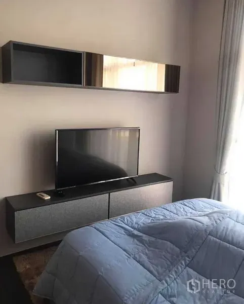 公寓 出租或出售在Watthana, Bangkok - 卧室内设电视柜与壁柜，配落地窗帘与舒适床品。