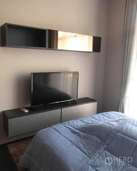 公寓 出租或出售在Watthana, Bangkok - 卧室内设电视柜与壁柜，配落地窗帘与舒适床品。