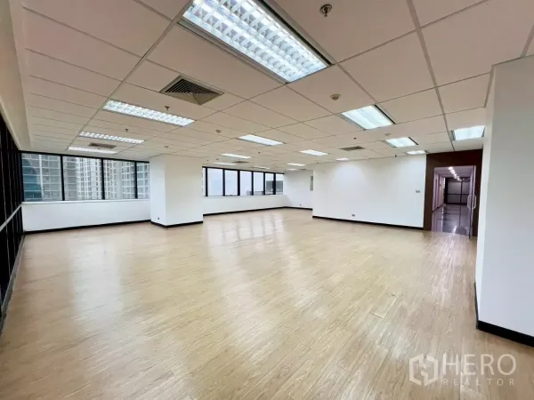 Office Space for rent in Huai Khwang, Bangkok - Spacious office floor with panoramic windows, bright lighting and doorway to the common corridor.