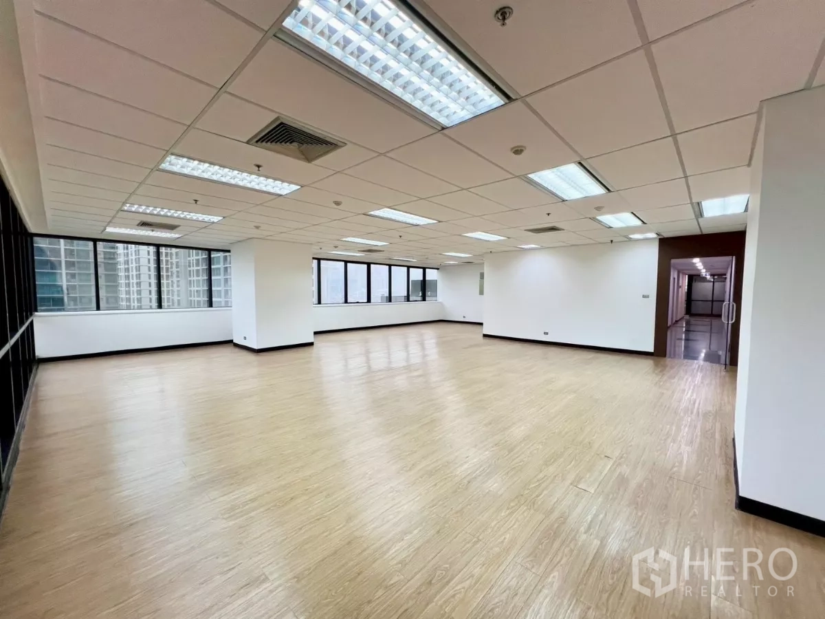 Office Space for rent in Huai Khwang, Bangkok - Spacious office floor with panoramic windows, bright lighting and doorway to the common corridor.