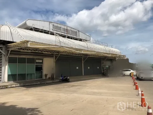Warehouse for rent in Bang Sue, Bangkok - Warehouse exterior with covered loading dock, multiple roller shutters and ample parking area.
