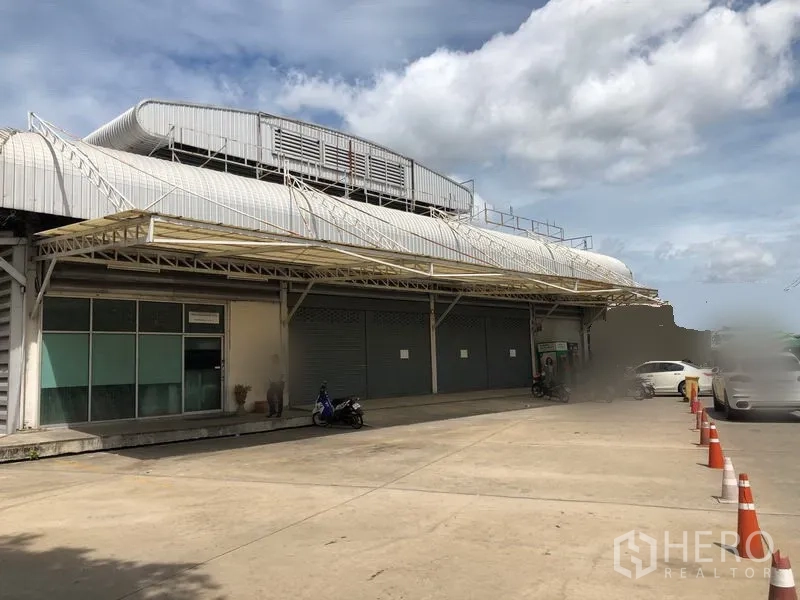 Warehouse for rent in Bang Sue, Bangkok - Warehouse exterior with covered loading dock, multiple roller shutters and ample parking area.