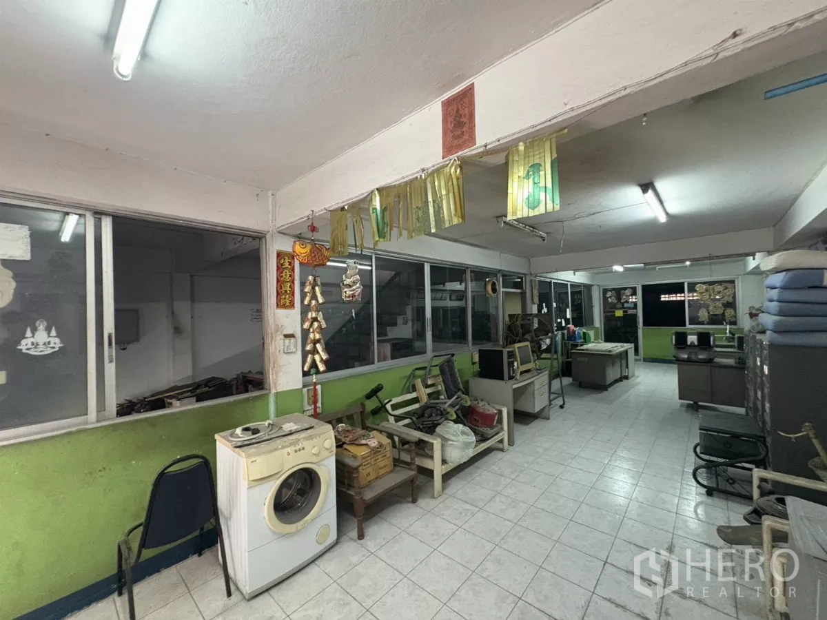 Warehouse for rent in Khlong Toei, Bangkok - Glass‑partitioned admin area with fluorescent lights and tiled flooring.