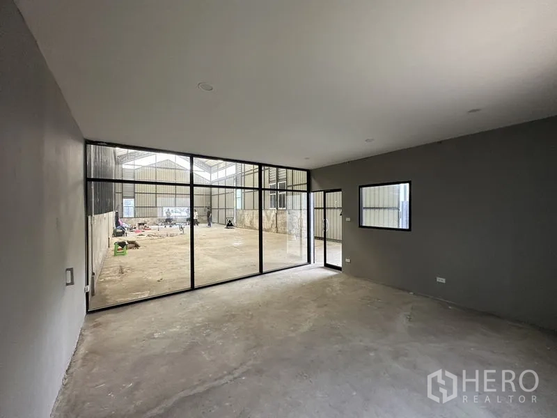 คลังสินค้า ให้เช่าในLat Phrao, Bangkok - ห้องออฟฟิศภายในผนังกระจกเต็มบาน หันหน้าเข้าสู่พื้นที่โกดัง ผนังสีเทา