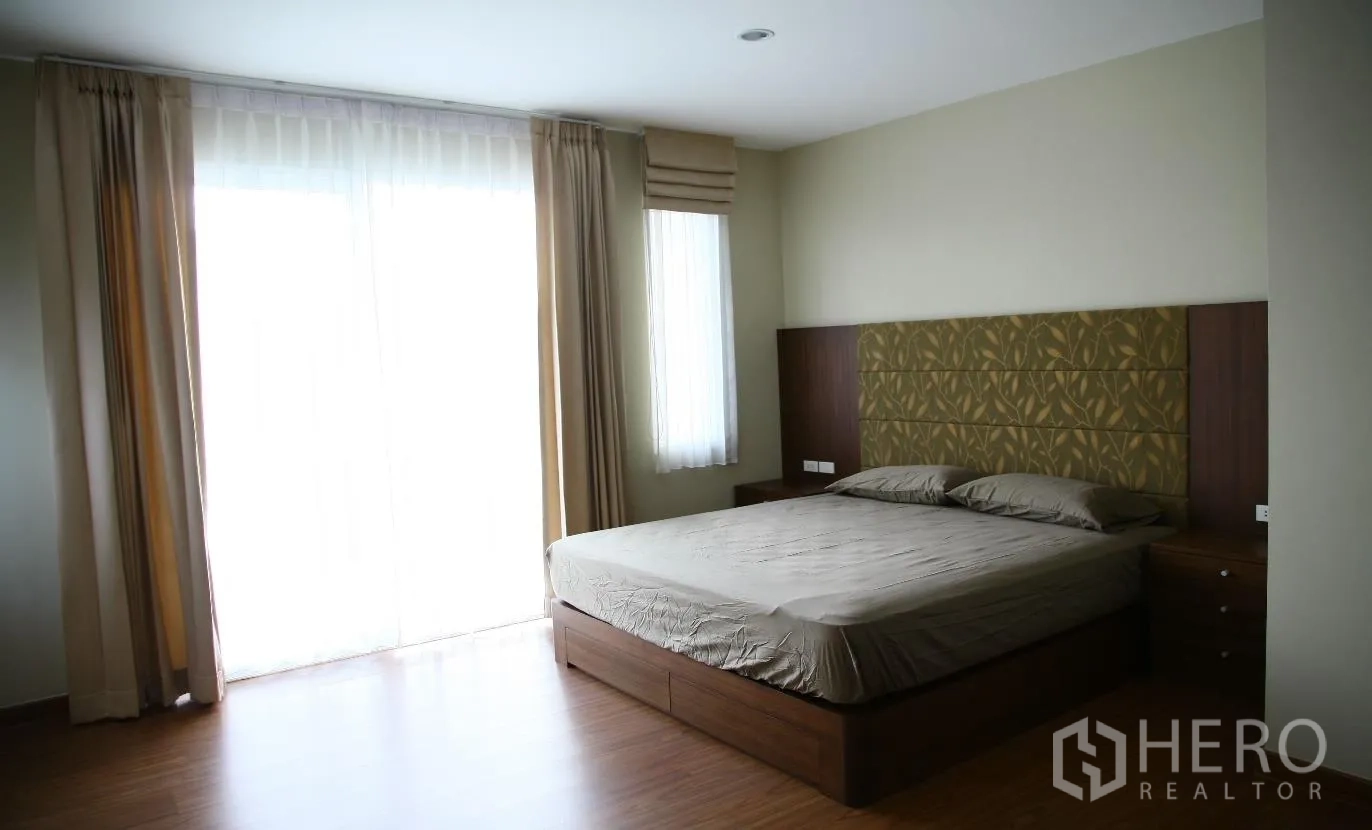 Detached House for rent or sale in Bang Na, Bangkok - Spacious master bedroom with upholstered headboard, king bed, wood flooring and floor-to-ceiling windows.