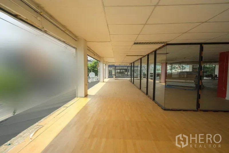 零售空间 出租在Watthana, Bangkok - 采光充足的零售内部，木地板、落地窗与玻璃隔间。