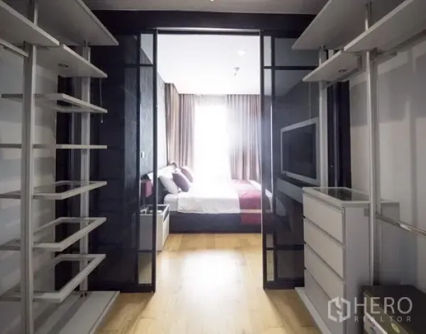 公寓 出租在Khlong Toei, Bangkok - 玻璃推拉门步入式衣帽间，层架与抽屉，连接采光充足的卧室