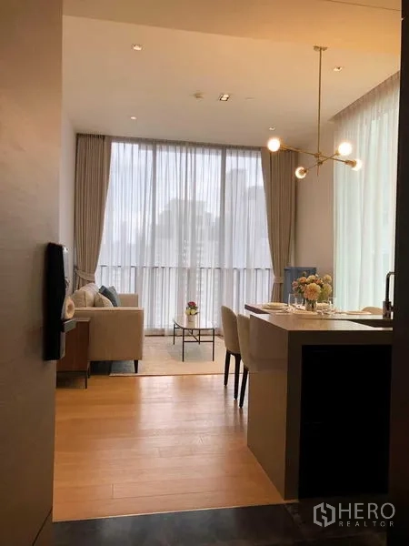 Condominium for rent - Entry view to a bright living area with kitchen island, chandelier and floor-to-ceiling curtains.
