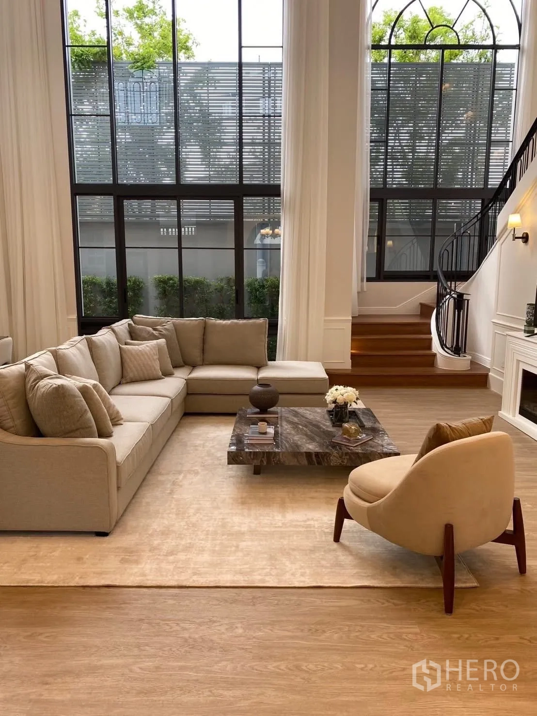 独立式住宅 出租在Bang Kapi, Bangkok - 挑高客厅，落地窗、L型沙发与弧形楼梯