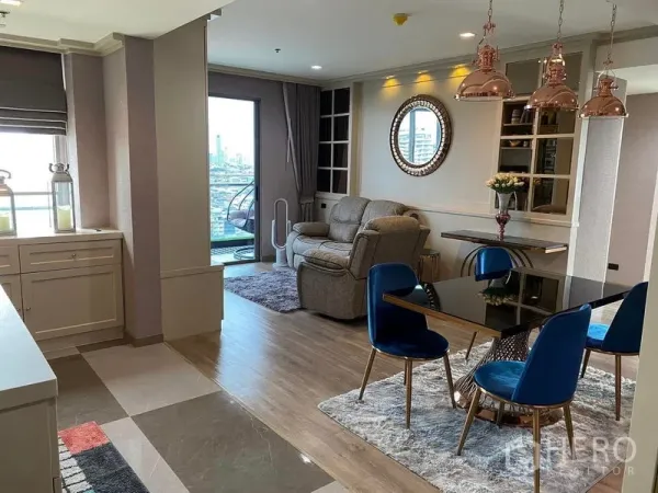 Condominium for sale in Bang Kho Laem, Bangkok - Open-plan living and dining with pendant lights and access to balcony.