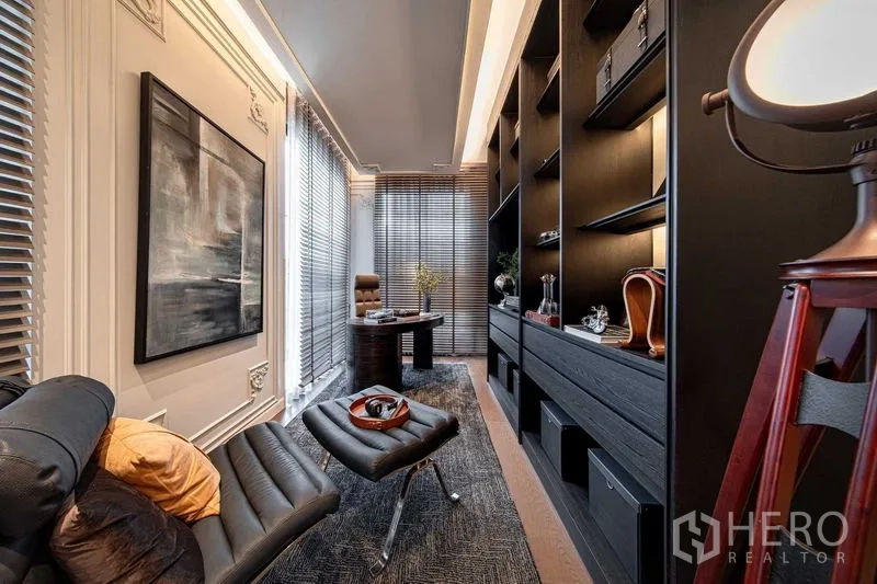 独立式住宅 出售在Saphan Sung, Bangkok - 现代书房，皮质躺椅、黑色一体柜与书架，靠近落地窗的书桌。