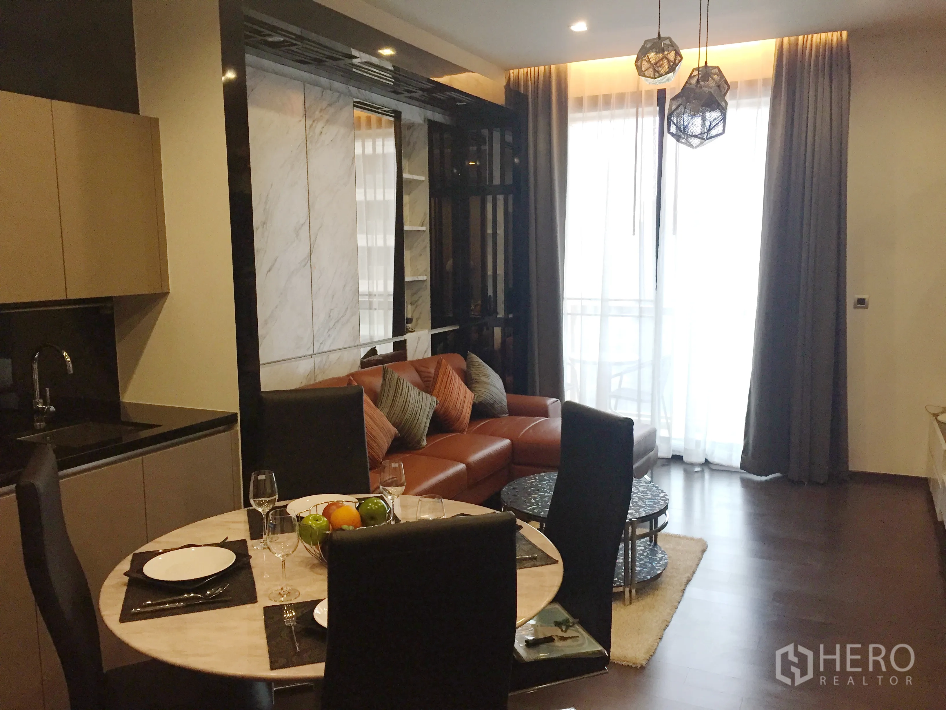 คอนโด ให้เช่าในWatthana, Bangkok - พื้นที่นั่งเล่นและรับประทานอาหารแบบเปิดโล่ง โซฟาหนัง โคมไฟแขวน และประตูกระจกออกสู่ระเบียง