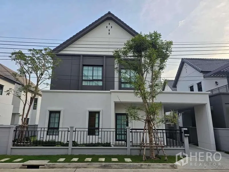 Detached House for rent in Bang Phli, Samut Prakan - Modern two-storey detached house with gabled roof, covered carport and landscaped front lawn.
