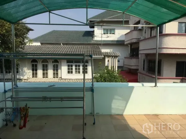 บ้าน ให้เช่าหรือขายในHuai Khwang, Bangkok - ดาดฟ้ามีหลังคาผ้าใบสีเขียวพร้อมราวตากผ้า มองเห็นบ้านข้างเคียง