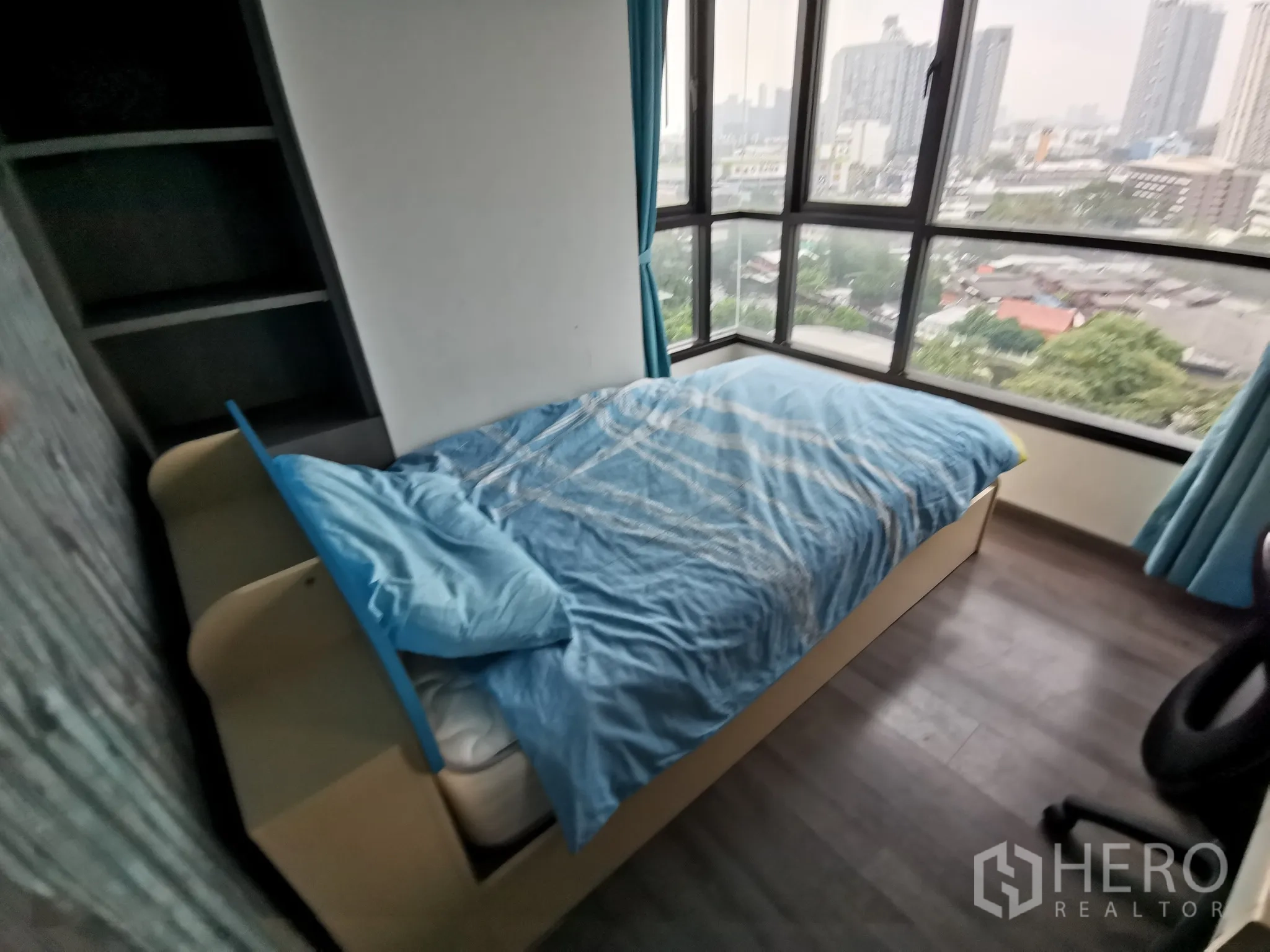 公寓 出租或出售在Watthana, Bangkok - 转角卧室设全景落地窗，单人床面向城市天际线。